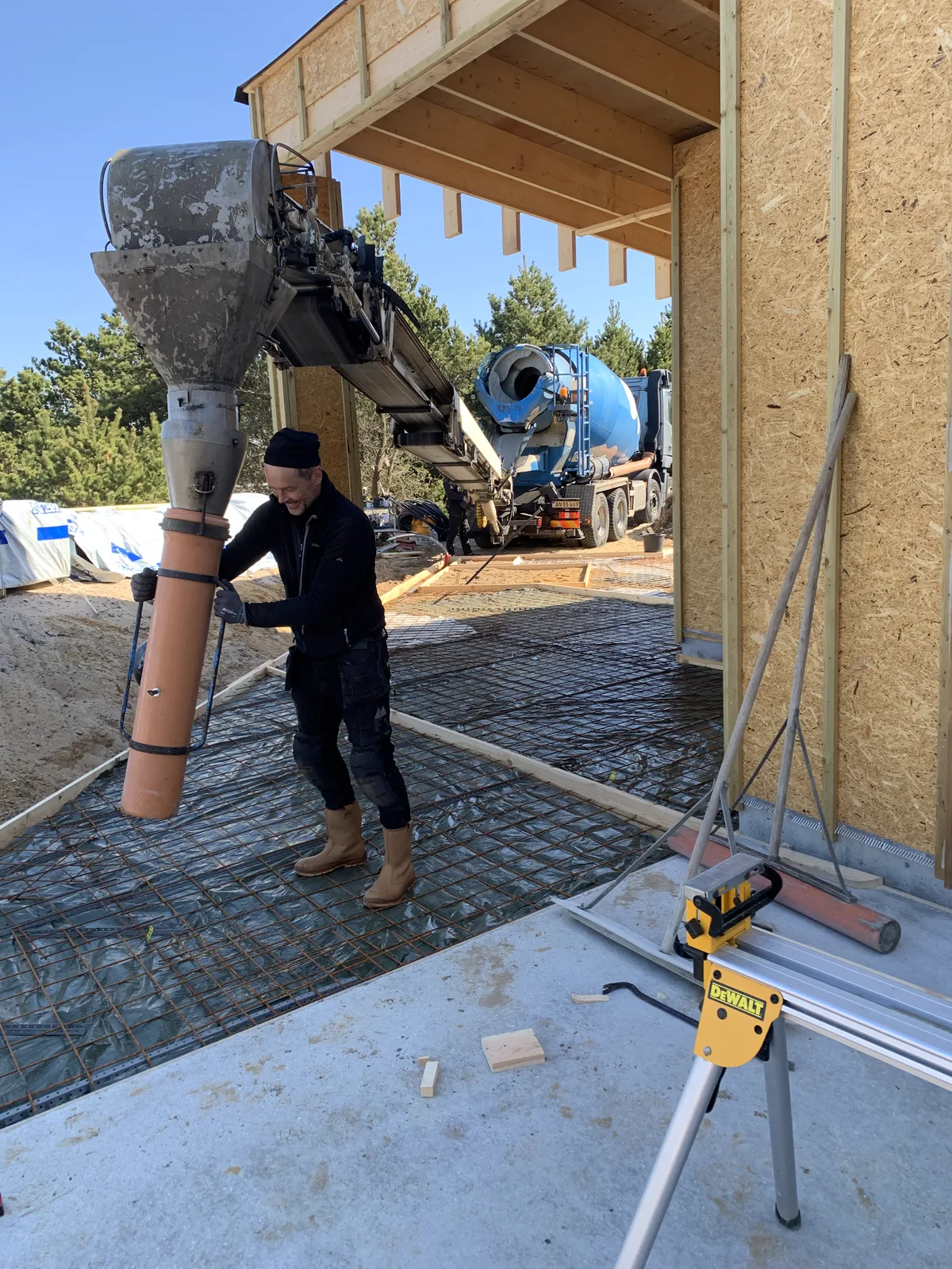 Beton lægges ud til ny betonterrasse under husets trækonstruktion